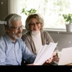 anciano-feliz-revisando-documentos-financieros