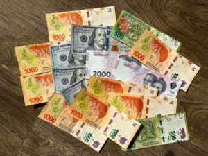 billetes argentinos y reloj representando inversiones