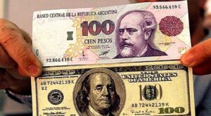 billetes de dolar estadounidense y signo peso argentino