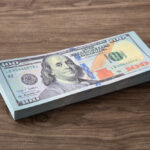 billetes-de-dolares-estadounidenses-sobre-mesa-madera