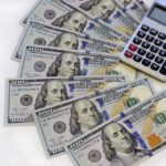 billetes-de-dolares-sobre-mesa-con-calculadora