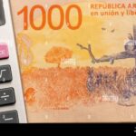 calculadora-y-billetes-argentinos-sobre-mesa-madera