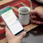 mano-sosteniendo-telefono-con-chat-de-whatsapp