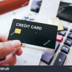 mano-sujetando-tarjeta-de-credito-y-calculadora