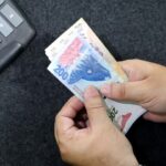 manos-contando-billetes-argentinos-y-calculadora