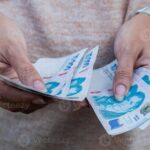 manos-contando-dinero-argentino-con-billetes