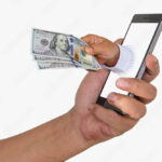 manos-entregando-dinero-con-telefono-movil