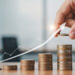 manos-entregando-monedas-con-grafico-financiero