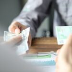 manos-intercambiando-billetes-y-documentos-financieros