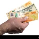 manos-sosteniendo-billetes-argentinos-y-dolares