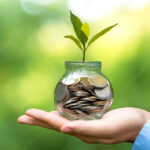 Cómo Hacer Que El Dinero Trabaje Para Mí y Generar Ingresos manos-sosteniendo-monedas-con-plantas-creciendo