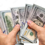 persona-contando-billetes-de-dolares-estadounidenses