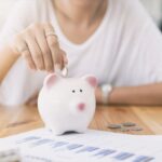 persona-guardando-dinero-en-alcancia-mensual