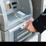 Cómo Retirar Dólares del Banco En Argentina Fácil y Seguro persona-retirando-dinero-en-cajero-automatico