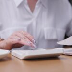 persona-revisando-documentos-con-calculadora-y-cafe