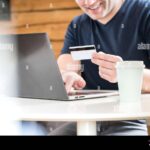 persona-usando-computadora-y-tarjetas-bancarias