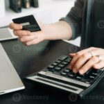 persona-usando-tarjeta-de-credito-y-calculadora